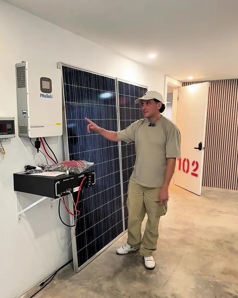 Francisco Carrizo explicando un inversor y paneles solares en la tienda
